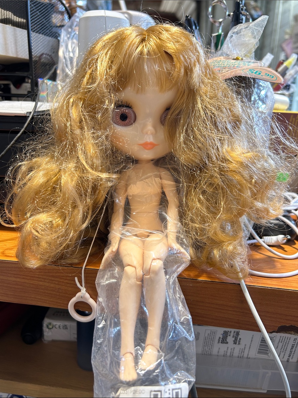 Blythe doll featuring long, wavy blonde hair and a jointed body.